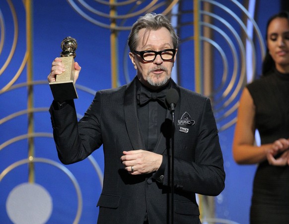 This image released by NBC shows Gary Oldman accepting the award for best actor in a motion picture drama for his role in &quot;The Darkest Hour,&quot; at the 75th Annual Golden Globe Awards in Beverl ...