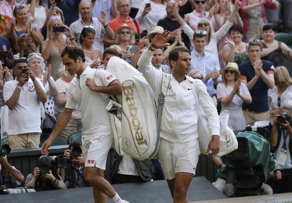 Switzerland&#039;s Roger Federer, left, leaves the court after beating Spain&#039;s Rafael Nadal, right, in a Men&#039;s singles semifinal match on day eleven of the Wimbledon Tennis Championships in  ...