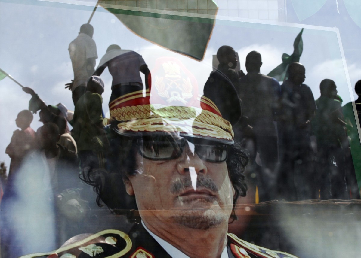 ZUM 5. JAHRESTAG DES AUSBRUCHS DES ARABISCHEN FRÜHLINGS IM DEZEMBER 2015 STELLEN WIR IHNEN FOLGENDES BILDMATERIAL ZUR VERFUEGUNG - Moammar Gadhafi's portrait is seen behind the window as people f ...
