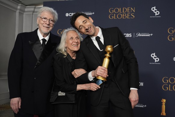 Elliot Brody, from left, Sylvia Plachy, and Adrien Brody, winner of the award for best performance by a male actor in a motion picture drama for &quot;The Brutalist&quot;, pose in the press room durin ...
