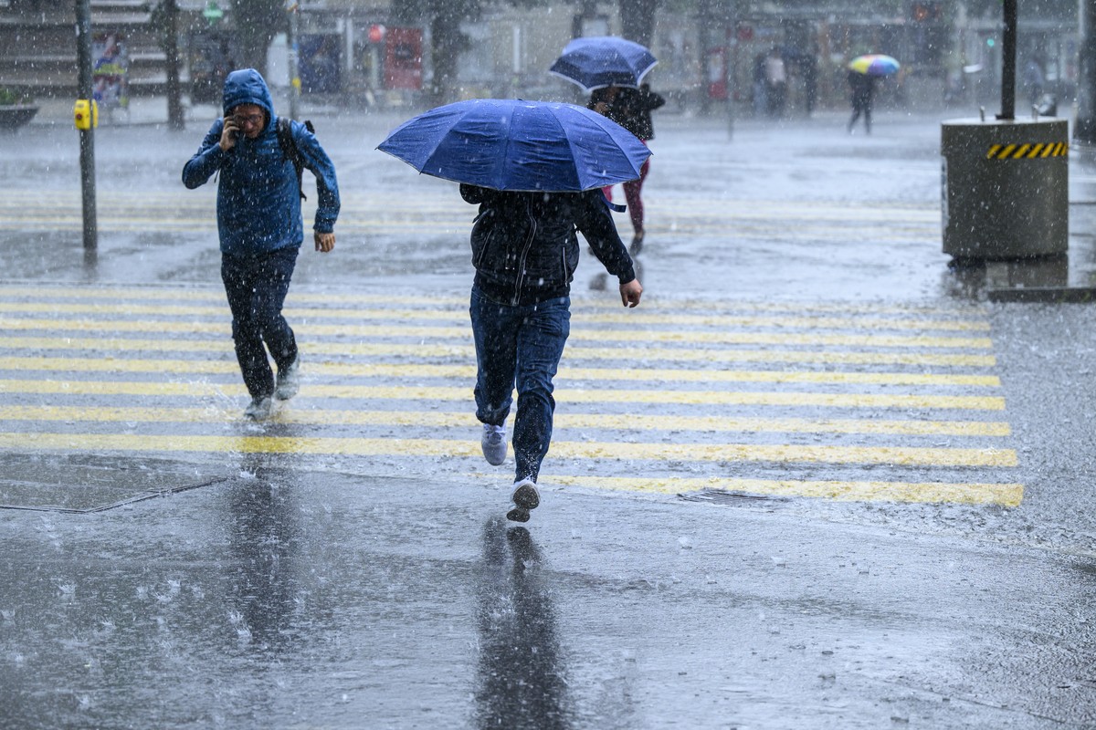 Passanten rennen durch den durch den Regen, fotografiert am Dienstag, 2. Juni 2026 waehrend eines Gewitters am Hischengraben in Bern. (KEYSTONE/Christian Beutler)