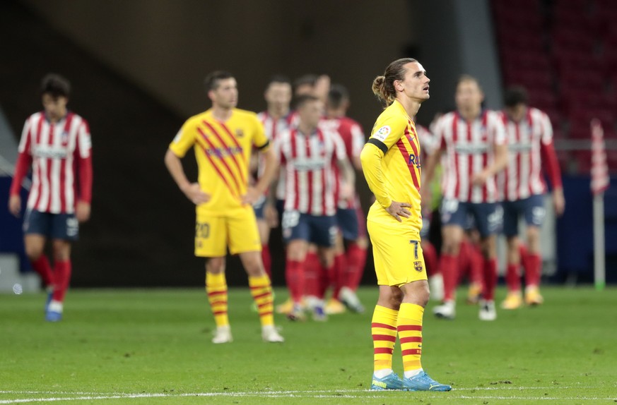 Barcelona&#039;s Antoine Griezmann reacts after Atletico Madrid&#039;s Yannick Carrasco scored his side&#039;s opening goal during the Spanish La Liga soccer match between Atletico Madrid and FC Barce ...