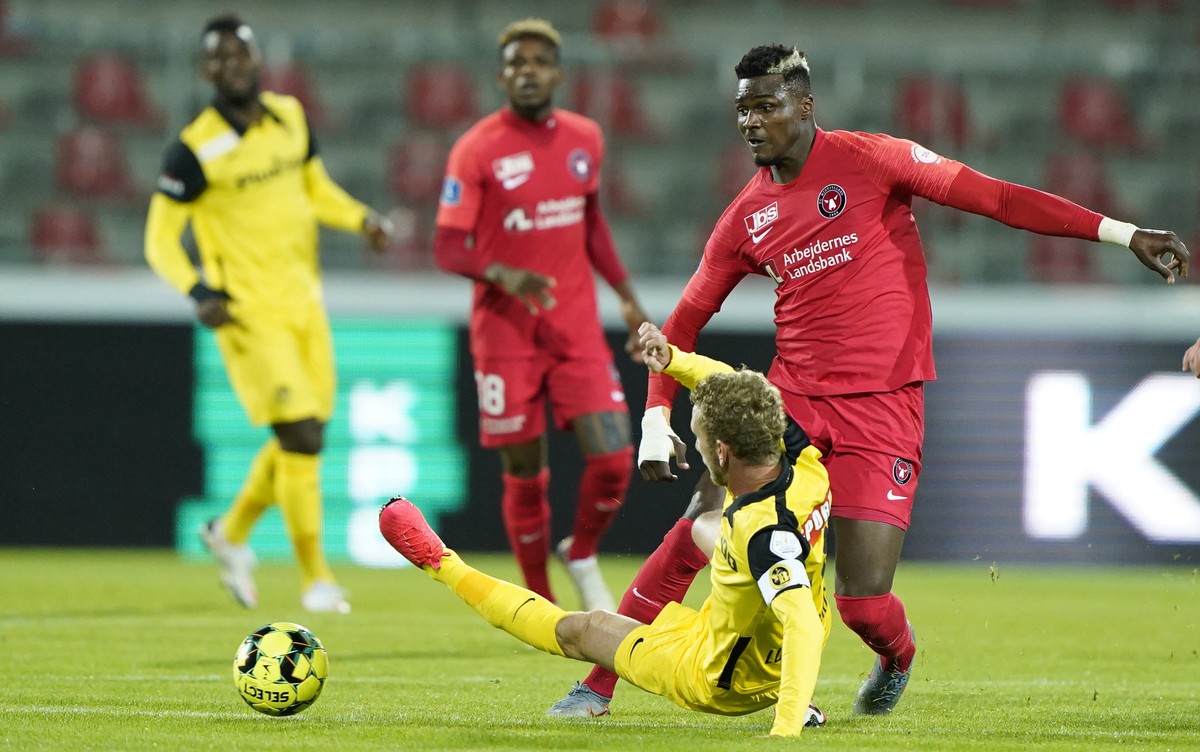 epa08674120 FC Midtjylland's Sory Kaba (R) and BSC Young Boys' Fabian Lustenberger (bottom) in action during the UEFA Champions League qualifying match between FC Midtjylland and BSC Young B ...