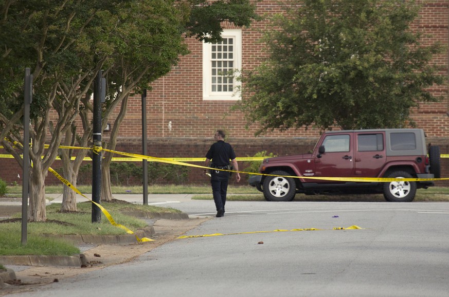 A police officer walks at the scene where eleven people were killed during a mass shooting at the Virginia Beach city public works building, Friday, May 31, 2019 in Virginia Beach, Va. A longtime, dis ...