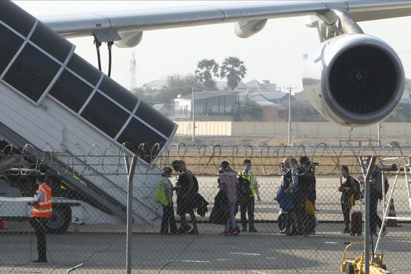 Foreign tourists board an Edelweiss Air plane bound for Zurich, Switzerland, at Phnom Penh International Airport in Phnom Penh, Cambodia, Friday, April 3, 2020. Foreign tourists are stranded in Cambod ...