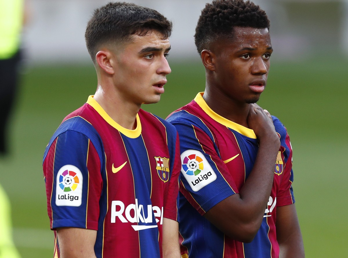 Barcelona's Pedri and Ansu Fati stand during the Spanish La Liga soccer match between FC Barcelona and Real Madrid at the Camp Nou stadium in Barcelona, Spain, Saturday, Oct. 24, 2020. (AP Photo/ ...