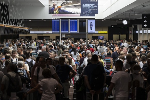 Menschen warten am Flughafen auf ihren Abflug in die Ferien, aufgenommen am Samstag, 16. Juli 2022 auf dem Flughafen in Zuerich. (KEYSTONE/Ennio Leanza)