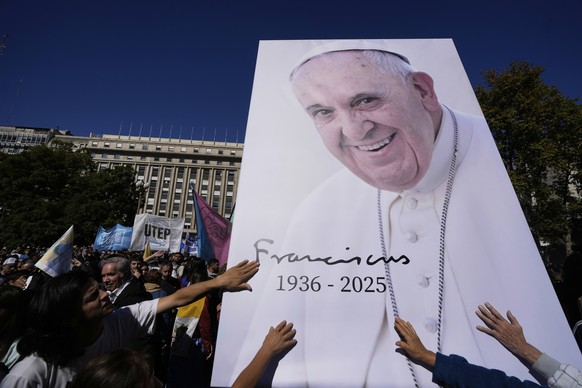 Mourners touch an image of the late Pope Francis outside the Cathedral in Buenos Aires, Argentina, Saturday, April 26, 2025, on the day of his funeral in Rome. (AP Photo/Natacha Pisarenko)
Argentina P ...