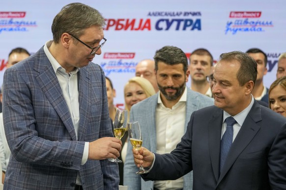 Serbian President Aleksandar Vucic, left, toasts with Serbian Interior Minister Ivica Dacic after his headquarter claimed victory in a local election in Belgrade, Serbia, Sunday, June 2, 2024. Tension ...