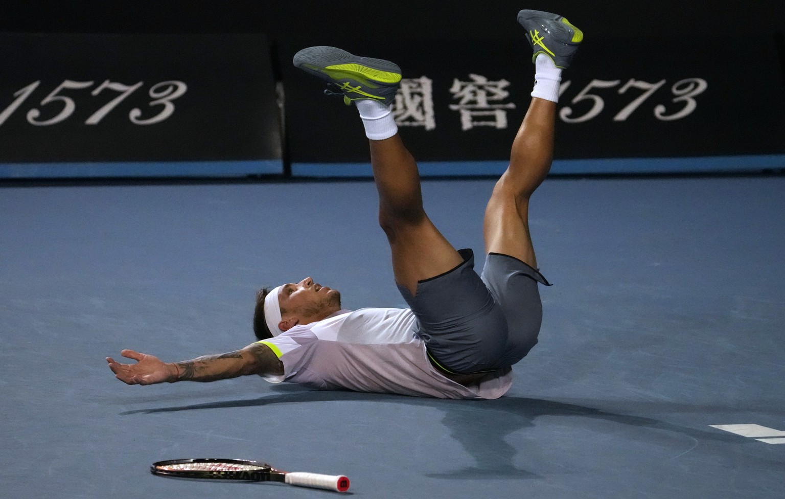 Alex Molcan of Slovakia falls onto the court after defeating Stan Wawrinka of Switzerland in their first round match at the Australian Open tennis championship in Melbourne, Australia, Monday, Jan. 16 ...