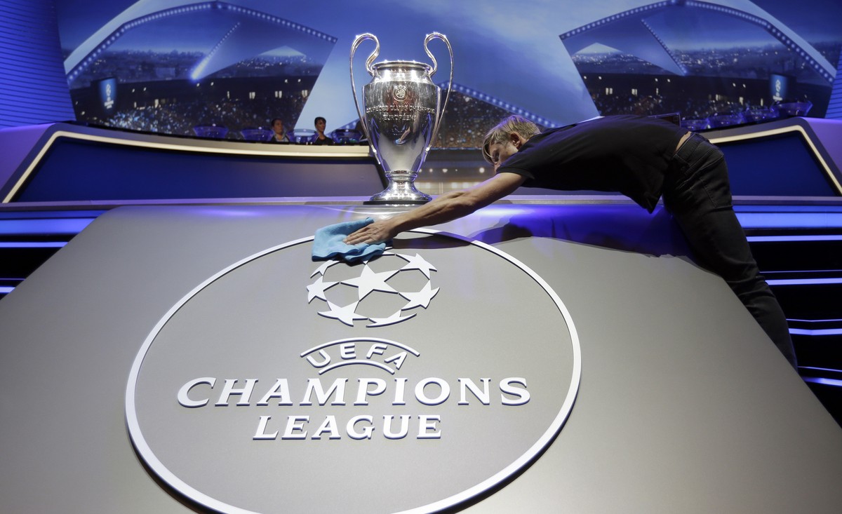 A man cleans the logo of UEFA Champions League before the UEFA Champions League draw at the Grimaldi Forum, in Monaco, Thursday, Aug. 24, 2017. (AP Photo/Claude Paris)