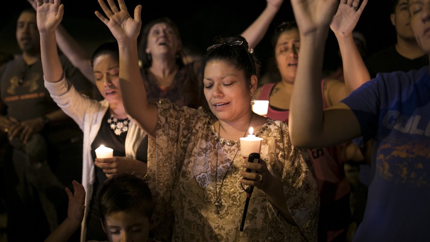 Mourners participate during a candlelight vigil held for the victims of a fatal shooting at the First Baptist Church of Sutherland Springs, Sunday, Nov. 5, 2017, in Sutherland Springs, Texas. (Jay Jan ...