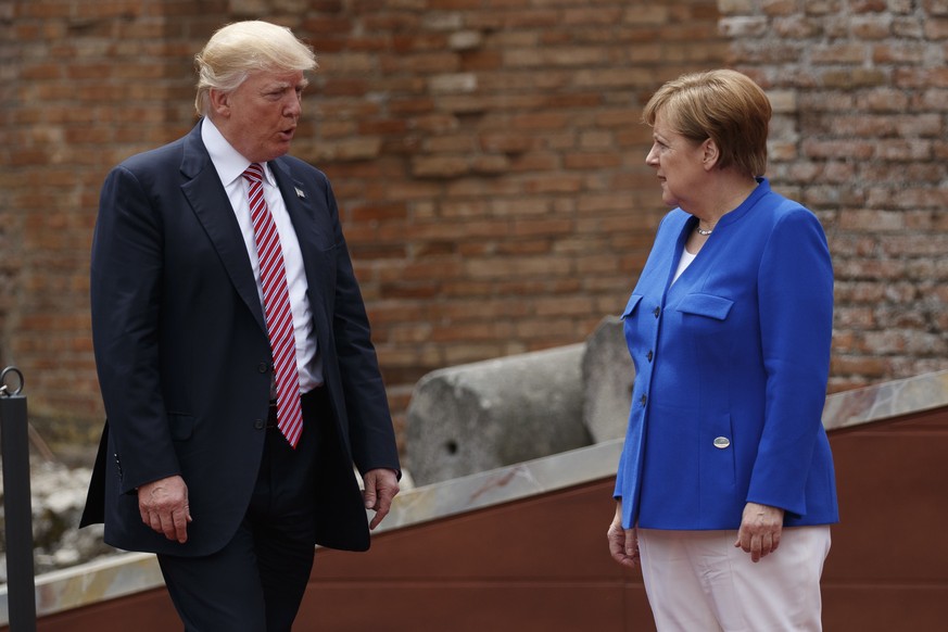 President Donald Trump and German Chancellor Angela Merkel arrive for a family photo with G7 leaders at the Ancient Greek Theater, Friday, May 26, 2017, in Taormina, Italy. (AP Photo/Evan Vucci)