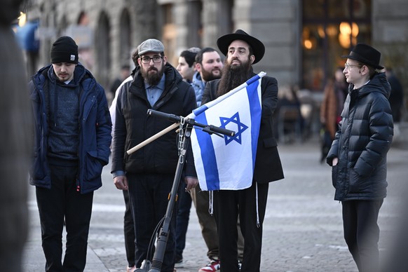 Kundgebung auf dem Helvetiaplatz nach einer Mahnwache in Zuerich am Sonntag, 3. Maerz 2024. Die Menschen trugen gelbe Regenschirme als Symbol gegen Antisemitismus. Am Samstagabend hatte ein Jugendlich ...