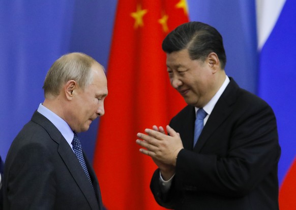 Chinese President Xi Jinping, right, and Russian President Vladimir Putin attend the ceremony of presenting Xi Jinping degree from St. Petersburg State University at the St. Petersburg International E ...