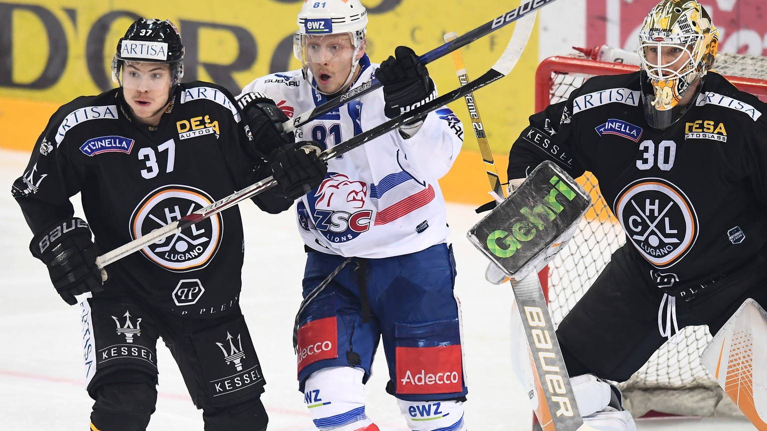 LuganoÕs player Elia Riva, Zurich&#039;s player Ronalds Kenins and LuganoÕs goalkeeper Elvis Merzlikins, from left, during the fifth match of the playoff final of the National League of the ice hockey ...