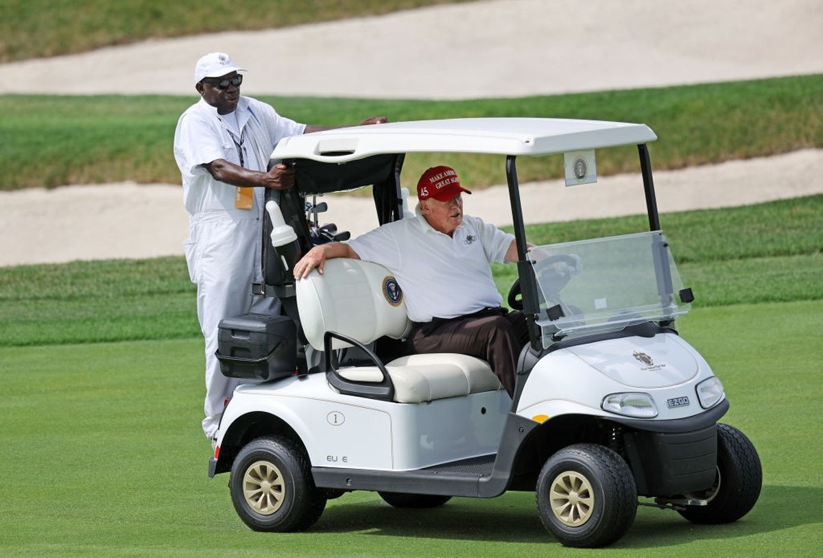 BEDMINSTER, NEW JERSEY - JULY 28: Former U.S. President Donald Trump drives a golf cart with his caddie on the first hole during the pro-am prior to the LIV Golf Invitational - Bedminster at Trump Nat ...