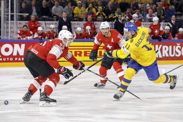 Switzerland&#039;s defender Michael Fora, left, vies for the puck with Sweden&#039;s forward Mikael Backlund, right, past Switzerland&#039;s defender Roman Josi, center, during the IIHF 2018 World Cha ...