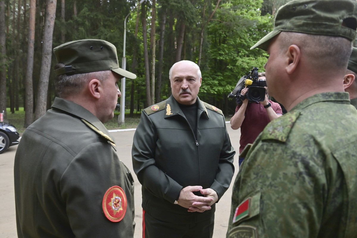 In this handout photo released by Belarus' Presidential Press Office, Belarusian President Alexander Lukashenko, center, speaks to officers as he visits the Central Command Post of the Air Force  ...
