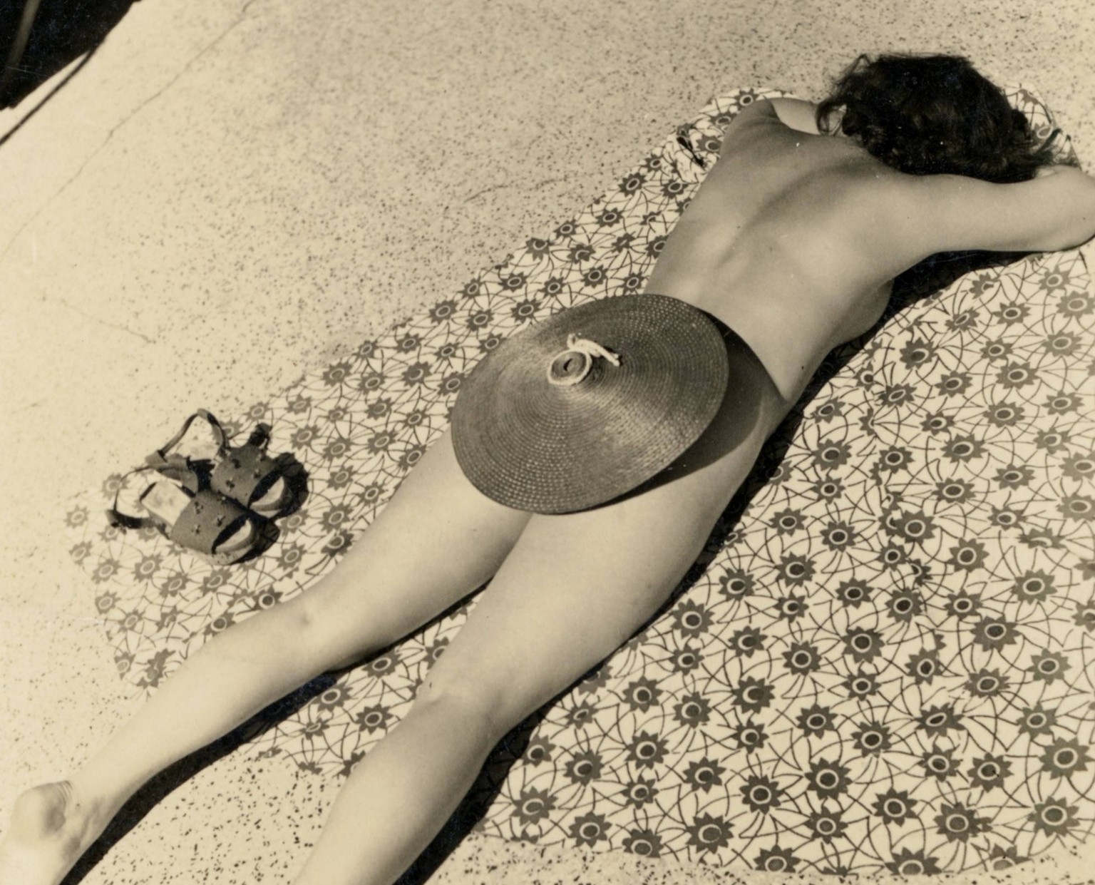 Baden, Bademode, Sonnen, Sommer, Frau liegt am Boden und sonnt sich auf einer gemusterten Unterlage, Sonnenhut, Humor, um 1950 Bathing, swimwear, sunbathing, summer, woman lying on the ground and bask ...