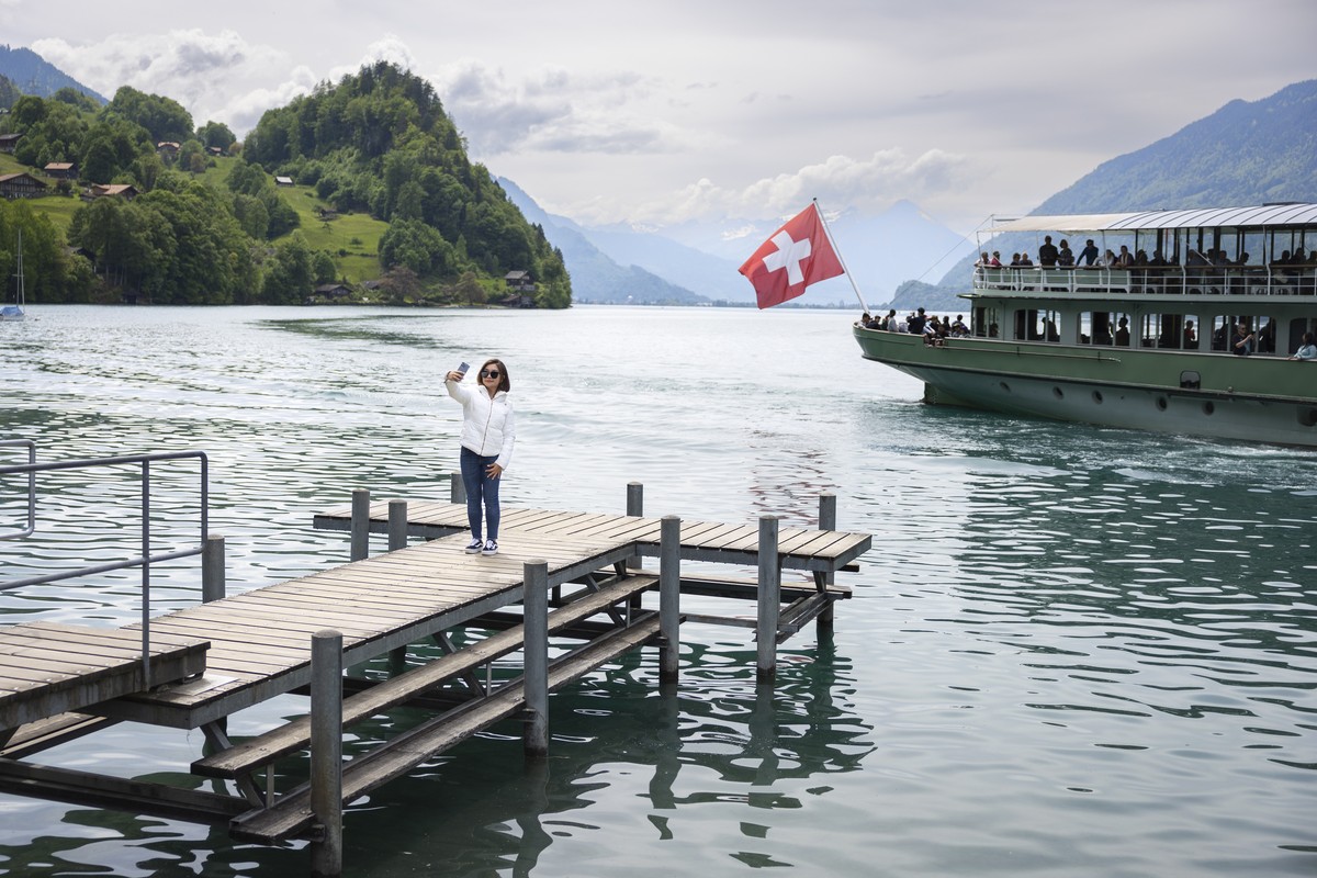 A Korean visitor takes selfie pictures at the pier in Iseltwald, Switzerland, Sunday, May 21, 2023. Lots of Asian TV fans and tourists visit the place because the romantic Korean Netflix drama 'C ...