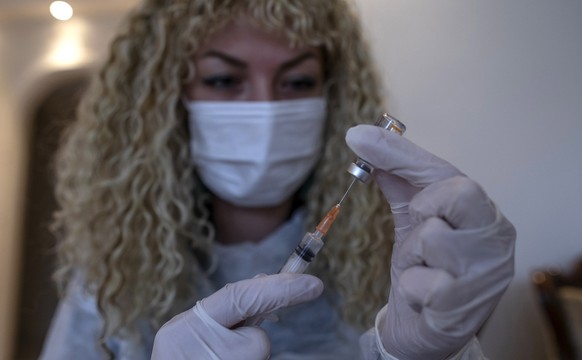 epa09015916 Turkish nurse Tugba Ozdemir (R) vaccinates Remzi Korkmaz, 74, against COVID-19 with Sinovac&#039;s vaccine, in Korkmaz&#039;s house during home visits for bedbound people&#039;s vaccinatio ...