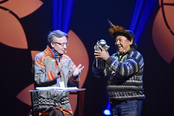 epa08044942 Presenter Lars Anders Baer (L) Davi Kopenawa, Hutukara Yanomami Association, Brazil receives the 2019 Right Livelihood Award at Cirkus, in Stockholm, Sweden, 04 December 2019. EPA/Erik Sim ...