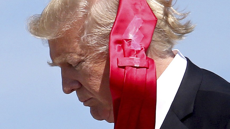 Wind blows President Donald Trump's tie as he arrives at Orlando International Airport for a visit to St. Andrew Catholic School in Orlando, Fla., Friday, March 3, 2017. (Joe Burbank/Orlando Sent ...
