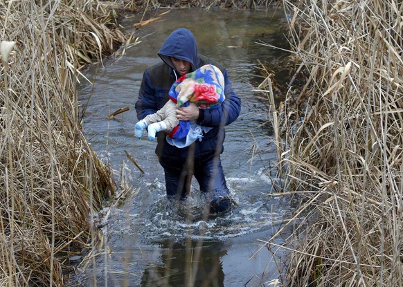 Ein Mann flieht mit seinem Baby aus dem Kosovo über die ungarisch-serbische Grenze in der Nähe des Dorfes Asotthalom am 6. Februar 2015.&nbsp;