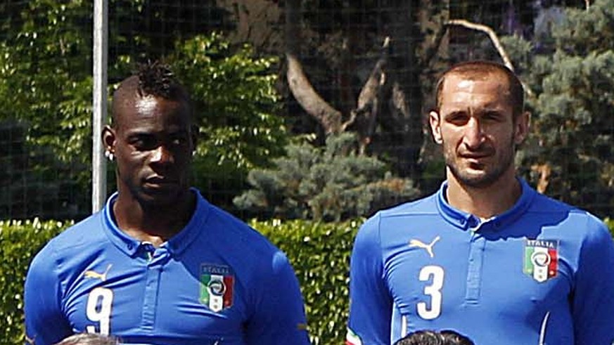 ADDS THE NAMES OF THE PLAYERS AND OFFICIALS Italian national soccer team pose with the official team jersey, at the Coverciano center, near Florence, Italy, Tuesday, June 3, 2014. Front row, from left ...