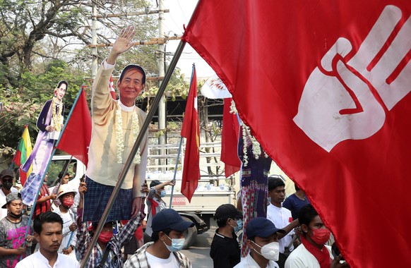 Protesters holds a portrait of deposed President Win Myint and leader Aung San Suu Kyi, during a demonstration in Mandalay, Myanmar, Monday, March 8, 2021. The escalation of violence in Myanmar as aut ...