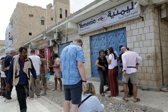epa12630810 Foreign tourists gather outside the closed office of Yemenia Airways on the island of Socotra, Yemen, 06 January 2026. Hundreds of foreign tourists have been left stranded on Socotra, in t ...