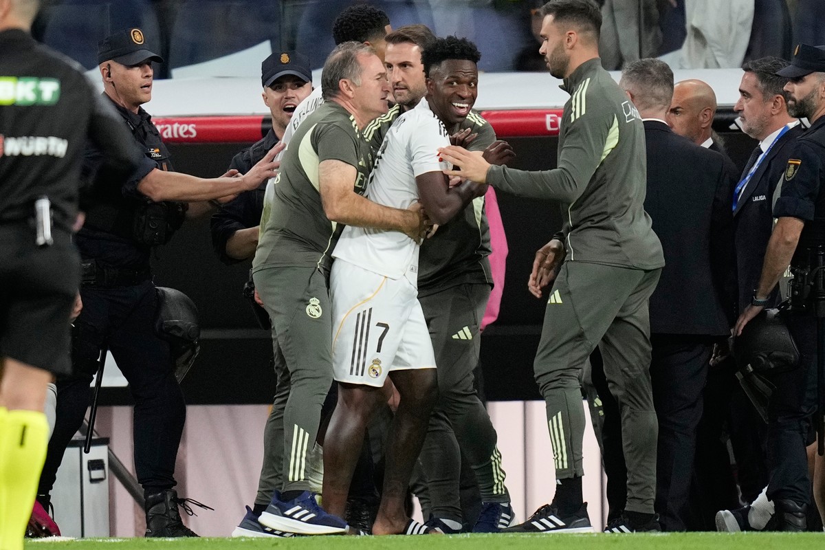 Real Madrid's Vinicius Junior is restrained by coaching staff duringa post match scuffle at La Liga soccer match between Real Madrid and Barcelona in Madrid, Spain, Sunday, Oct. 26, 2025. (AP Pho ...