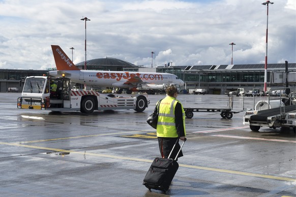 ZU DEN ZAHLEN DES EUROAIRPORTS BASEL-MUELHAUSEN STELLEN WIR IHNEN FOLGENDES THEMENBILD ZUR VERFUEGUNG - Eine Mitarbeiterin der Fluggessellschaft Easy Jet geht vor einem Flugzeug vorbei auf dem Rollfel ...