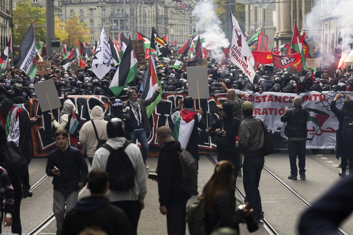 People hold banners and wave Palestinian flags during an unauthorized rally in solidarity with the Palestinian people in Bern, Switzerland, 11 October 2025. (KEYSTONE/Peter Klaunzer)