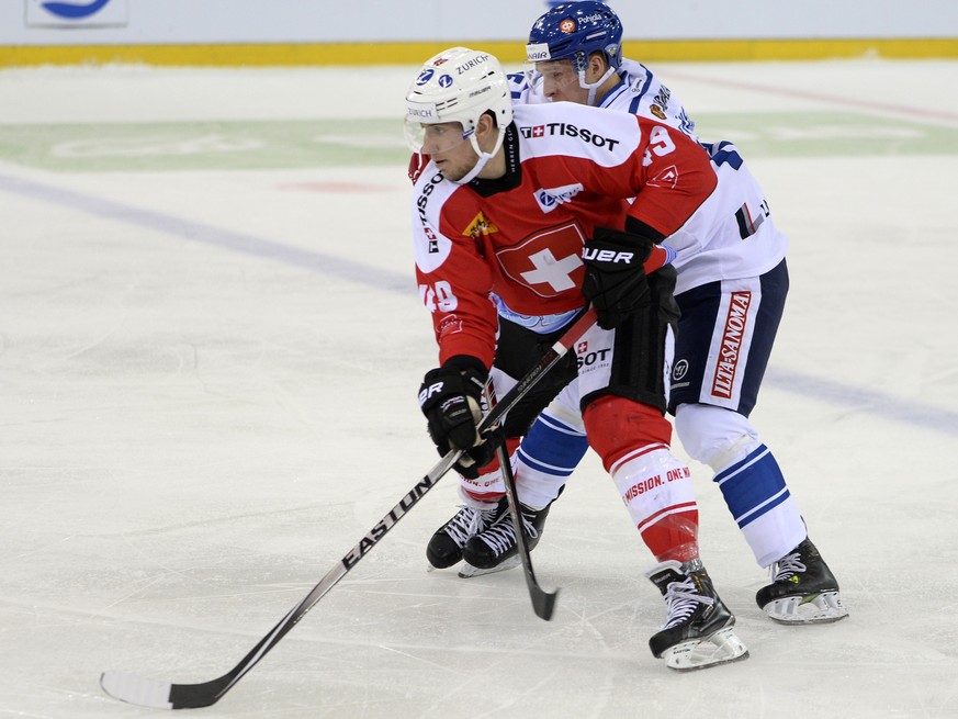 Der Schweizer Matthias Rossi, links, im Kampf um den Puck gegen den Finnen Juha-Pekka Hytoenen, rechts, im Eishockey WM Vorbereitungsspiel der Schweiz gegen Finnland in der St. Jakob-Arena in Basel, a ...