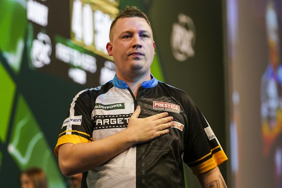 Chris Dobey of England celebrates after winning his round 4 match against Kevin Doets of the Netherlands at the World Darts Championship in London, Monday, Dec. 30, 2024. (AP Photo/Alberto Pezzali)