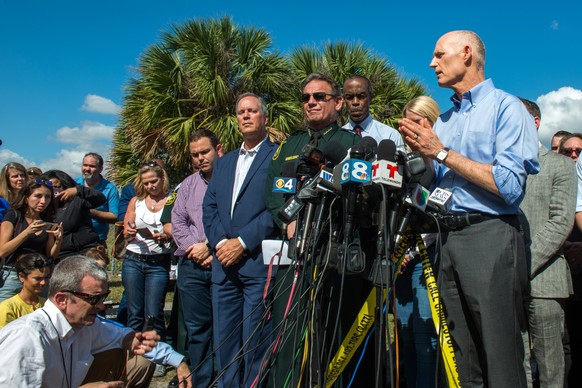 epa06529133 Governor of Florida Rick Scott (R) speaks at a press conference on the outskirts of Marjory Stoneman Douglas High School, Parkland, Florida, USA, 15 February 2018. The governor updated the ...