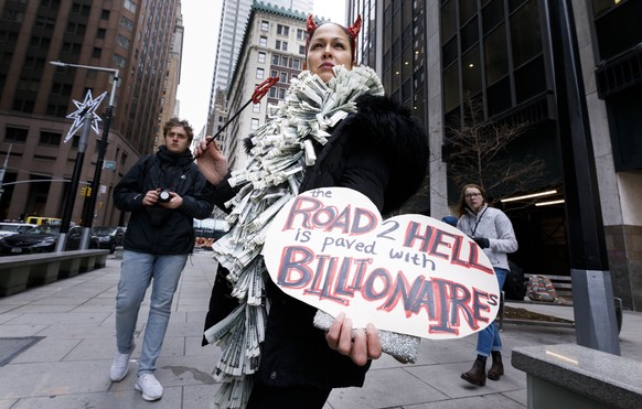 epa07371931 (FILE) - A woman holds a sign during a protest against Amazon&#039;s plans to open new company headquarters in New York, New York, USA, 30 November 2018 (reissued 15 February 2019). Accord ...