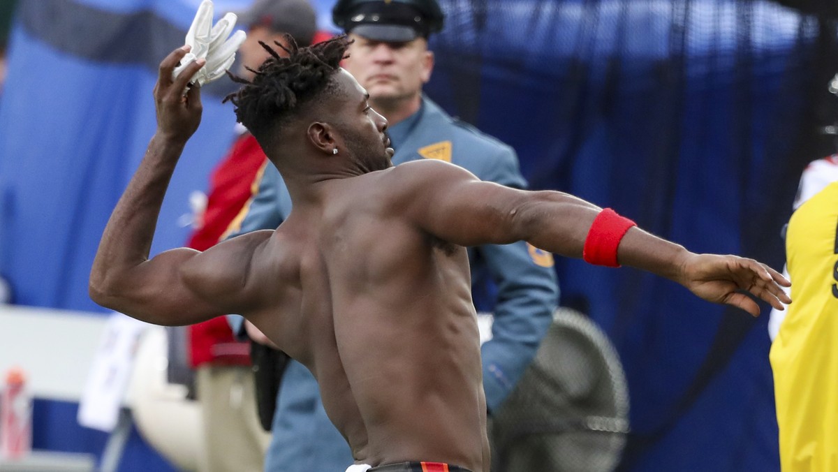 A N.J. State Police trooper, background, watches as Tampa Bay Buccaneers wide receiver Antonio Brown (81) throws his gloves into the stands while his team's offense is on the field against the Ne ...