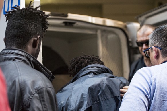 Two of the three migrants, left, and second from left, accused of hijacking a vessel enter a police van after being escorted out of a couthouse in Valletta, Malta, Saturday, March 30, 2019. Three teen ...