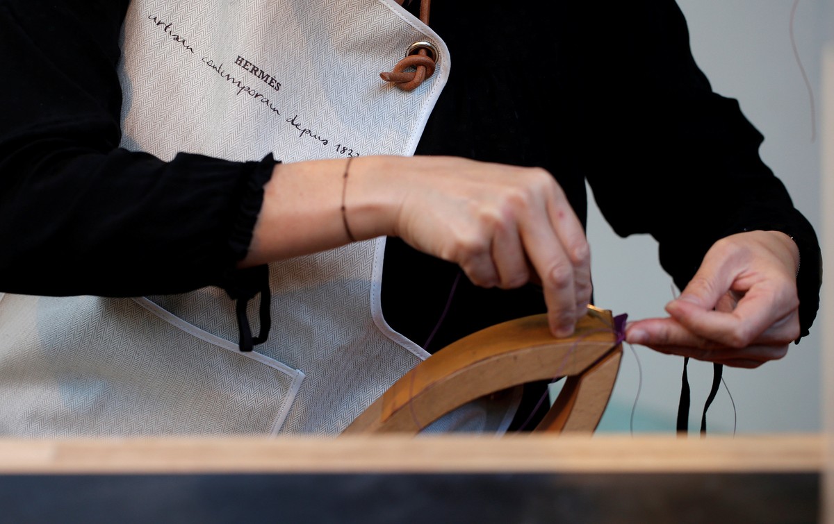 A leather craftswoman works on a Hermes luxury good displayed during the "Hermes hors les murs" (Hermes outdoors) event in Paris, France, November 18, 2016. REUTERS/Christian Hartmann