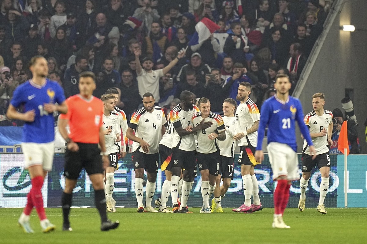 Germany players celebrate after Germany's Florian Wirtz scored his side's opening goal during an international friendly soccer match between France and Germany at the Groupama stadium in Dec ...