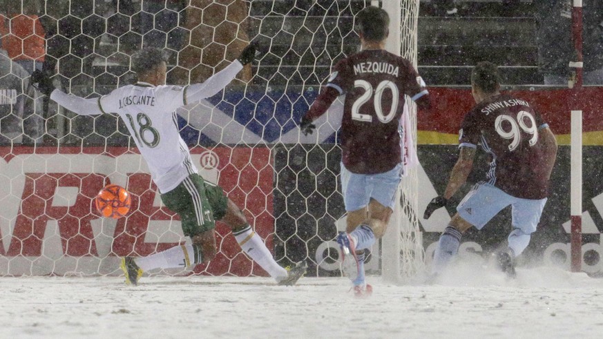 Colorado Rapids forward Andre Shinyashiki (99) scores the game-tying goal past Portland Timbers defender Julio Cascante (18) as Rapids forward Nicolas Mezquida (20) trails the play the second half of  ...