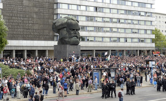 Protesters gather for a far-right protest in front of a Karl Marx monument in Chemnitz, Germany, Monday, Aug. 27, 2018 after a man has died and two others were injured in an altercation between severa ...