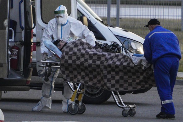 Medical workers carry a suspect COVID-19 patient on a stretcher at a hospital in Kommunarka, outside Moscow, Russia, Monday, Nov. 22, 2021. Russia&#039;s coronavirus death toll was still hovering near ...
