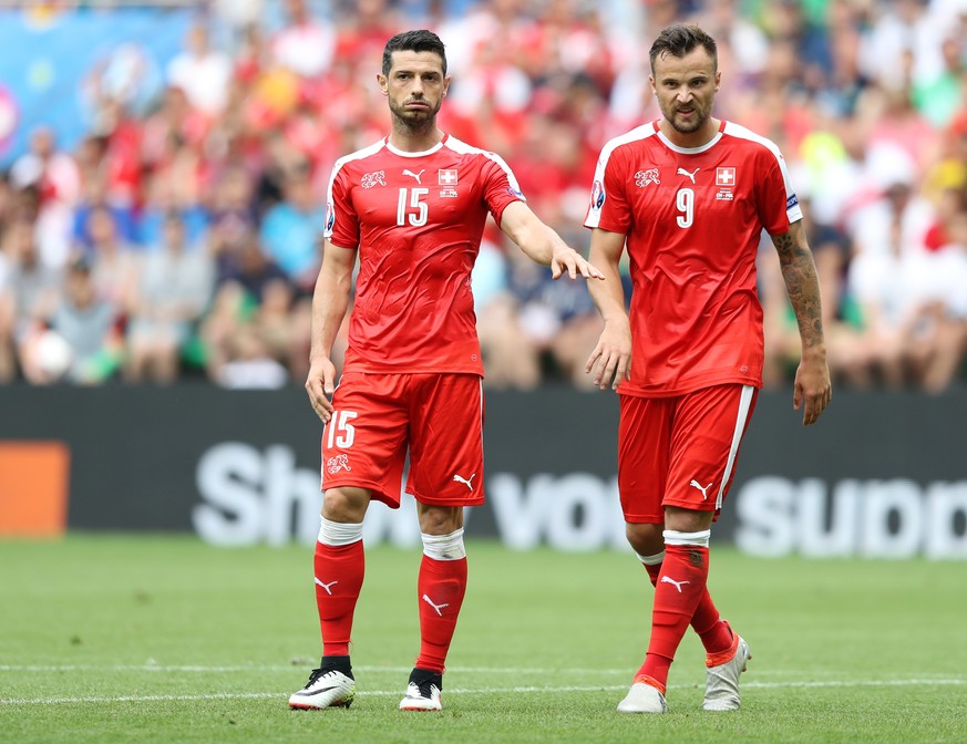 Switzerland&#039;s Blerim Dzemaili, left, and Haris Seferovic stand on the pitch during the Euro 2016 round of 16 soccer match between Switzerland and Poland, at the Geoffroy Guichard stadium in Saint ...