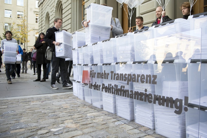 Personen laufen mit den Boxen, die Unterschriften enthalten, in Richtung Bundeshaus-West wahrend der Einreichung der Transparenz-Initiative, am Dienstag, 10. Oktober 2017 in Bern. Das ueberparteiliche ...