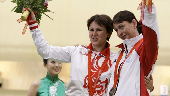 Russia&#039;s Natalia Paderina, left, and Georgia&#039;s Nino Salukvadze hug and wave during the medal ceremony after the women&#039;s 10 meter air pistol final at the Beijing 2008 Olympics in Beijing ...