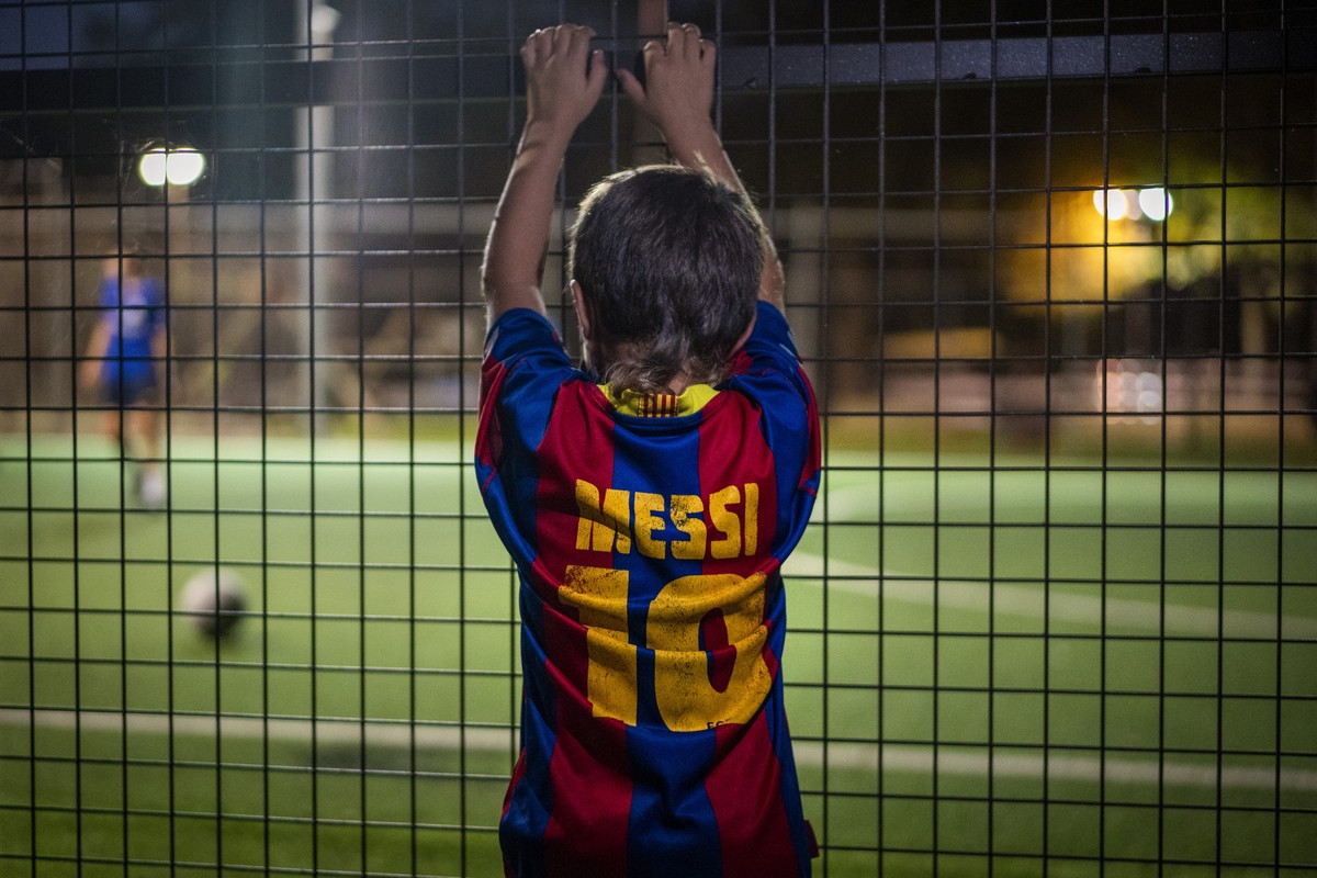 A boy wearing a shirt with the name of Barcelona soccer player Lionel Messi looks at at a soccer match in Banyoles, in Girona province, Spain on Wednesday, Sept. 2, 2020. Lionel Messi's future at ...